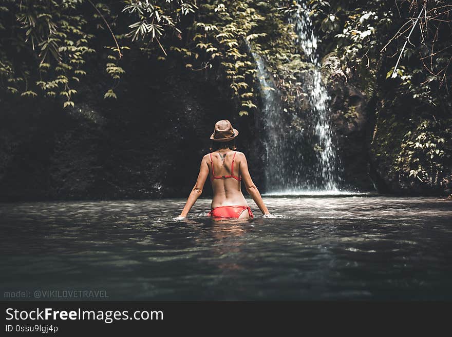 Young woman tourist in the deep jungle with waterfall. Real adventure concept. Bali island. Indonesia. Young woman tourist in the deep jungle with waterfall. Real adventure concept. Bali island. Indonesia.