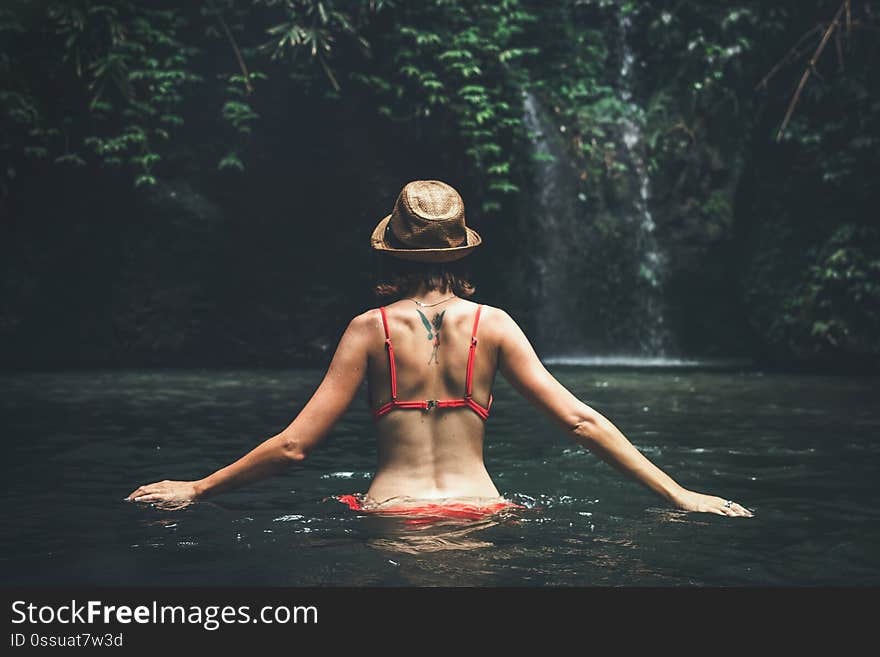 Young woman tourist in the deep jungle with waterfall. Real adventure concept. Bali island. Indonesia. Young woman tourist in the deep jungle with waterfall. Real adventure concept. Bali island. Indonesia.