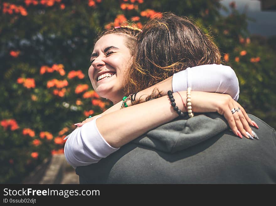 Cheerful smiling couple in love hugging in nature on a beautiful flower background. Bali island.