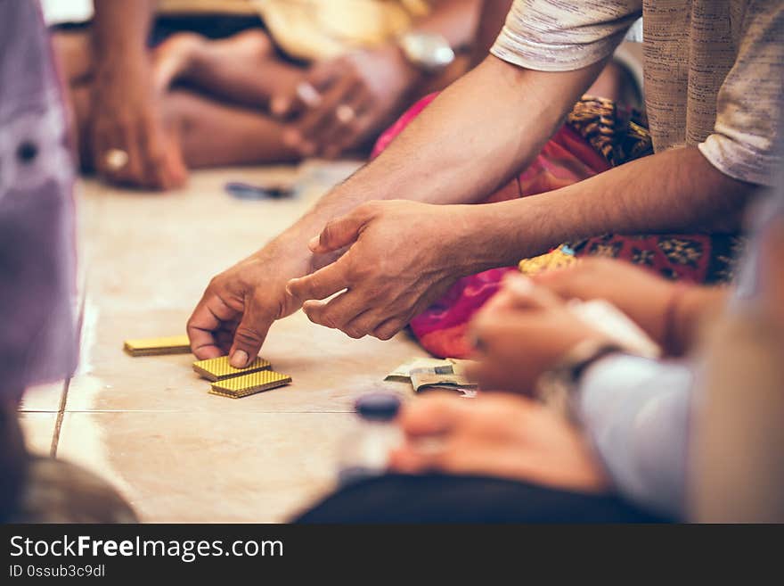 Group of balinese men playing cards sitting on the floor. Bali island. Indonesia.