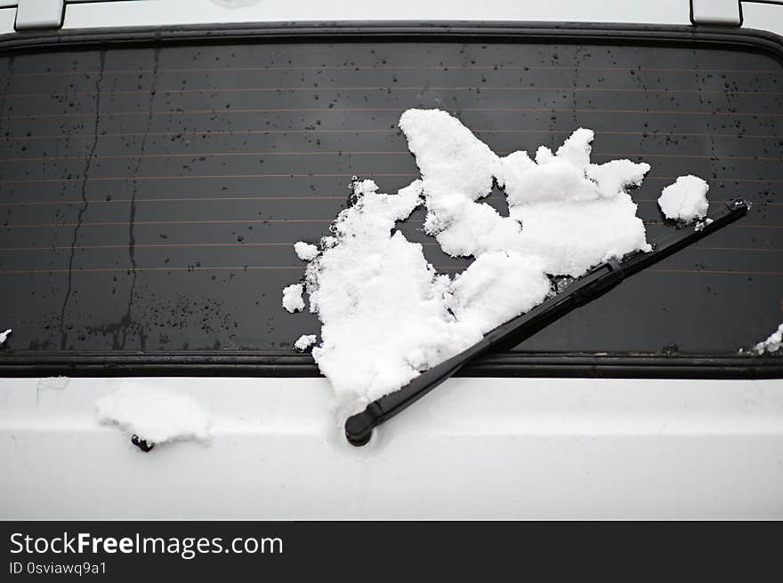 Cold winter weather concept of car trunk with window and wiper covered with white snow. Cold winter weather concept of car trunk with window and wiper covered with white snow