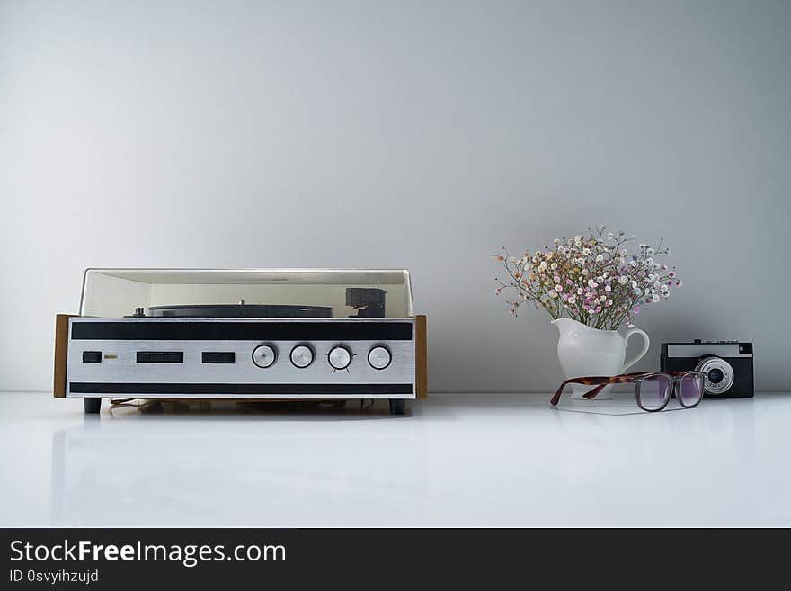 Composition with retro stereo radio and other vintage things with a gentle bouquet of flowers on a light gray background