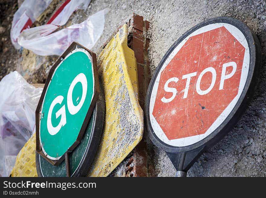 Stop and go signs lying on street