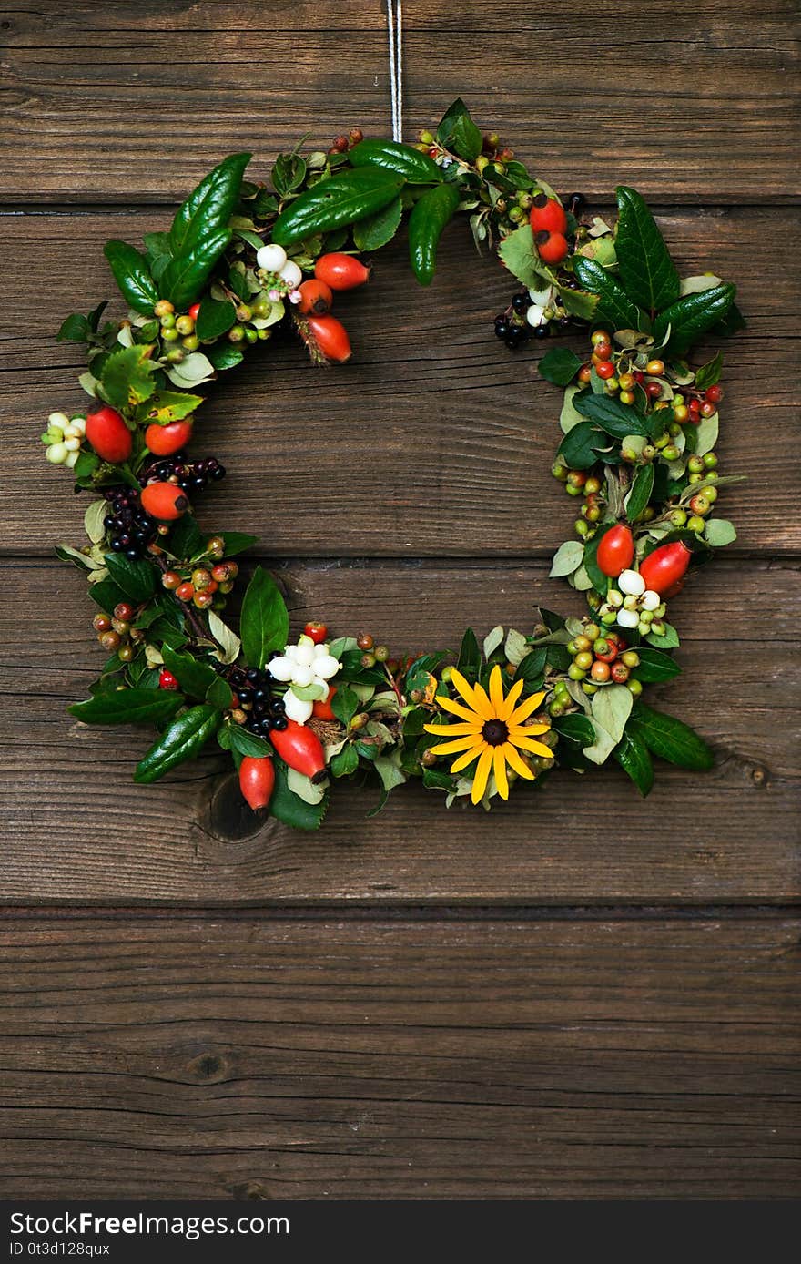 Autumn wreath with berries on a wodden background