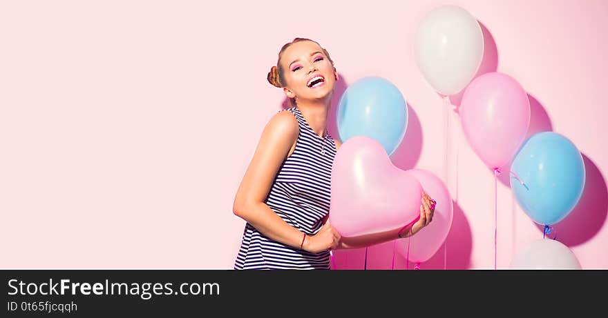 Beauty girl with colorful air balloons laughing over pink background. Beautiful Happy Young woman on birthday holiday party