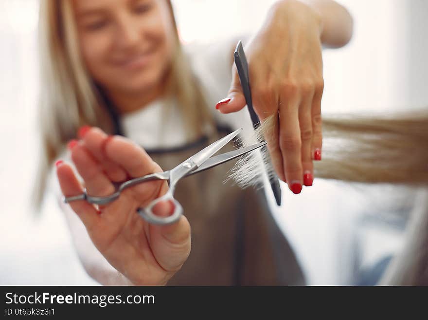 Hairdresser cut hair her client in a hair salon