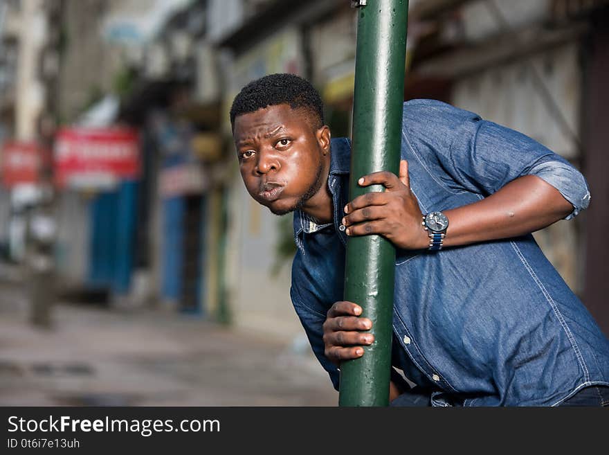 Young african man behind iron bar looking at the camera, surprised. Young african man behind iron bar looking at the camera, surprised