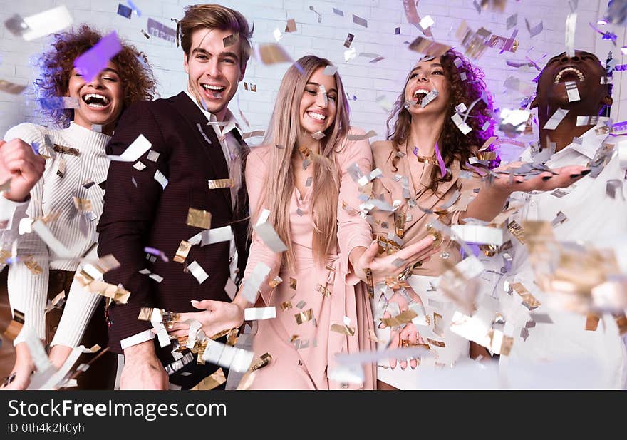 Party. Joyful Diverse Friends Having Fun Standing Under Falling Confetti Celebrating New Year Or Christmas Holiday Indoor. Party. Joyful Diverse Friends Having Fun Standing Under Falling Confetti Celebrating New Year Or Christmas Holiday Indoor