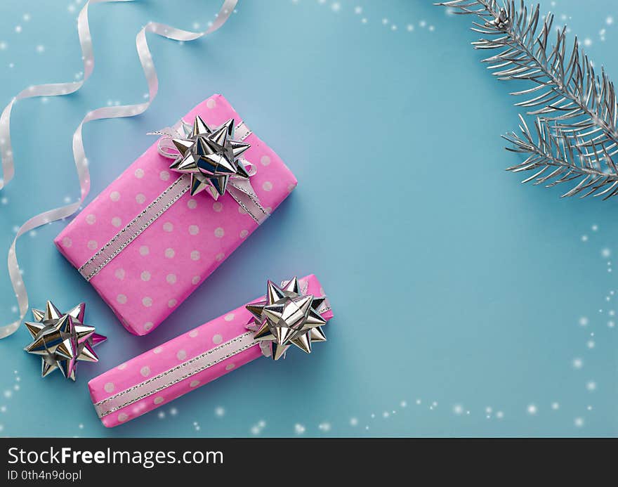 Christmas holidays decorations. Pink gift boxes on pastel blue background. Frame composition, copy space