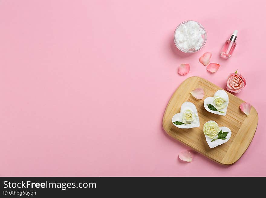 Flat lay composition with natural handmade soap and ingredients on pink background. Space for text