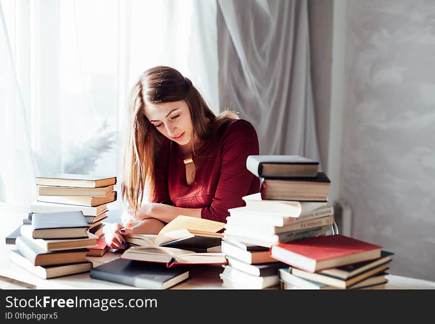 Girl reading book prepares for the exam in the library