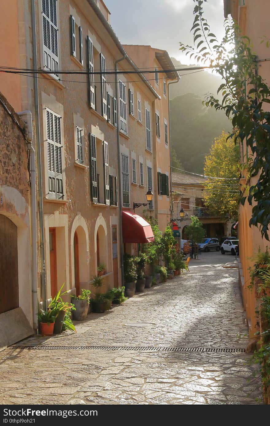 The photo shows the street of the old village of Valldemossa in the mountains of the island of Palma de Mallorca. Photo taken before sunset. The photo shows the street of the old village of Valldemossa in the mountains of the island of Palma de Mallorca. Photo taken before sunset