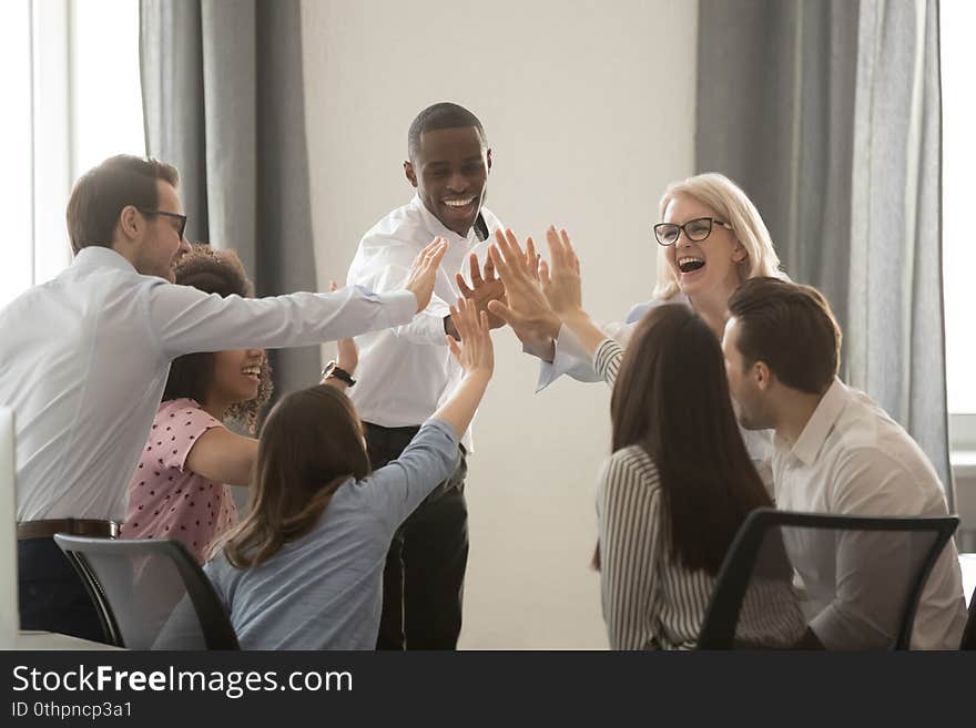 Excited multiethnic colleagues give high five achieving shared business goal together, happy diverse employees join hands motivated for success and high results at meeting in office. Teamwork concept. Excited multiethnic colleagues give high five achieving shared business goal together, happy diverse employees join hands motivated for success and high results at meeting in office. Teamwork concept