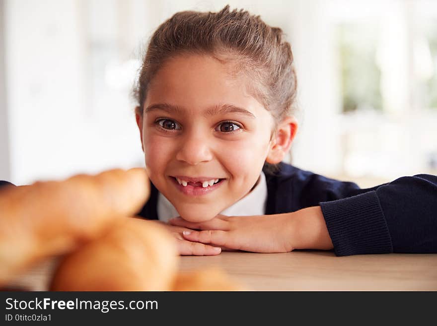 Mischievous Girl Wearing School Uniform Taking Croissant From Kitchen Counter