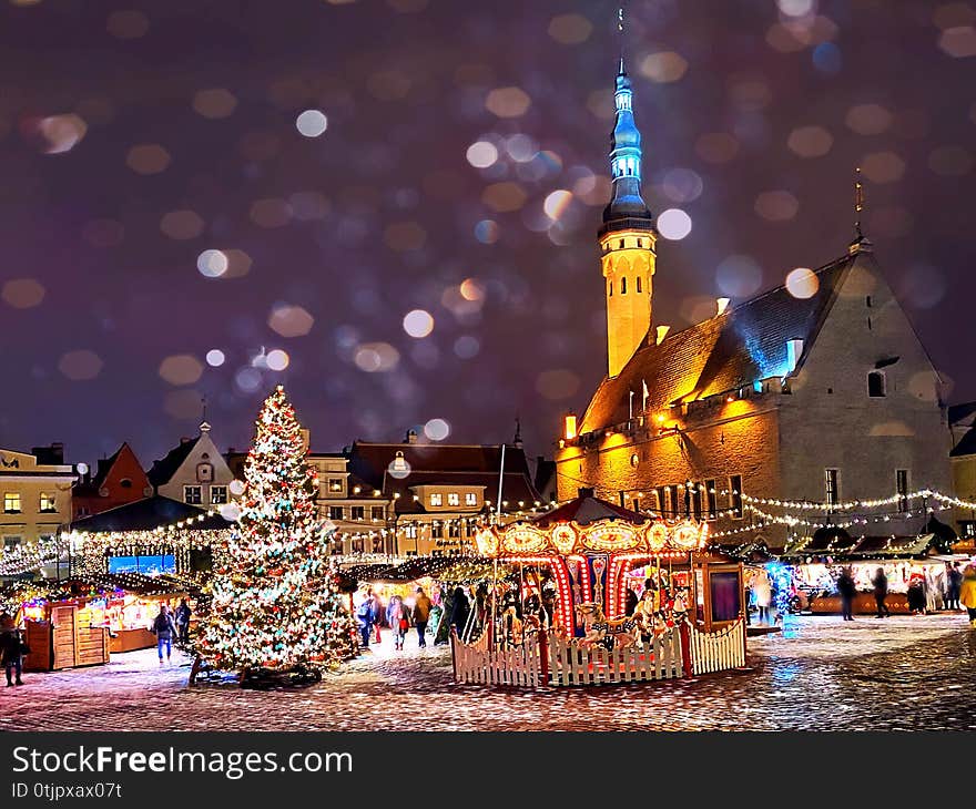 Christmas in the city  holiday New year  evening light  and snowflakes fall  in Tallinn old town squar town hall square, best mark