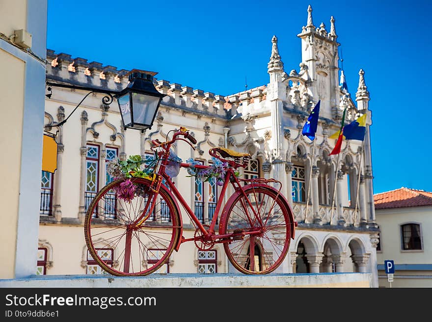 An old decorated bicycle and Sintra Town Hall building on background in a beautiful sunny day