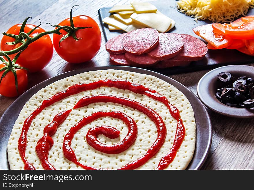 Cooking pizza at home. Ingredients for cooking pizza are on a wooden table.