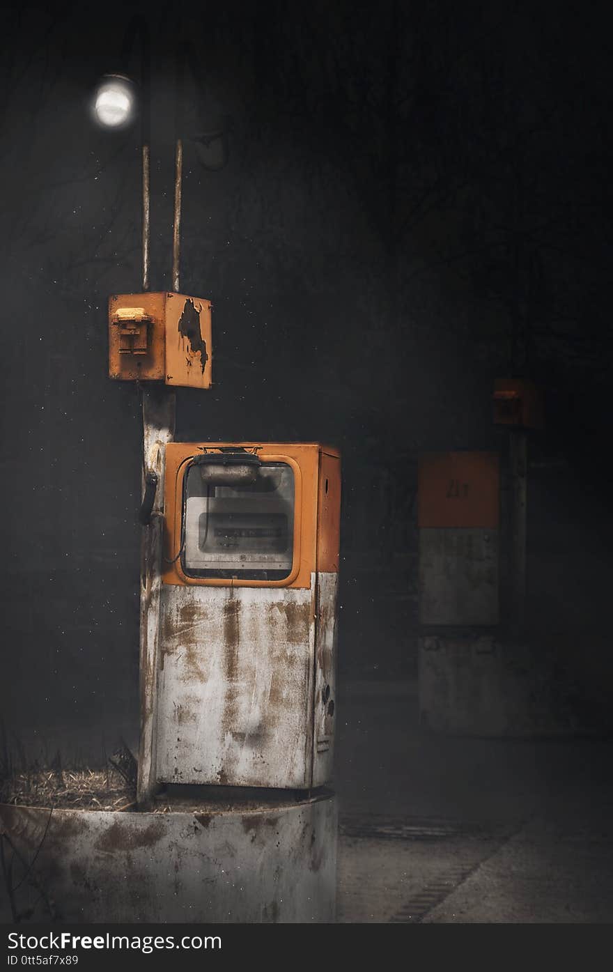 Old abandoned retro gas station at night under one lamp, mysticism, horror movie