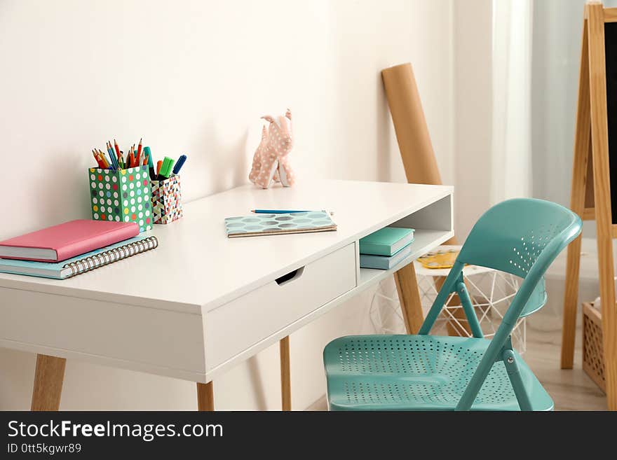 Table with chair near white wall in room