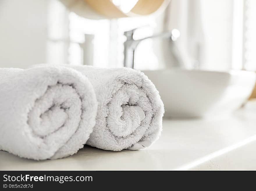 Clean rolled towels on countertop in bathroom