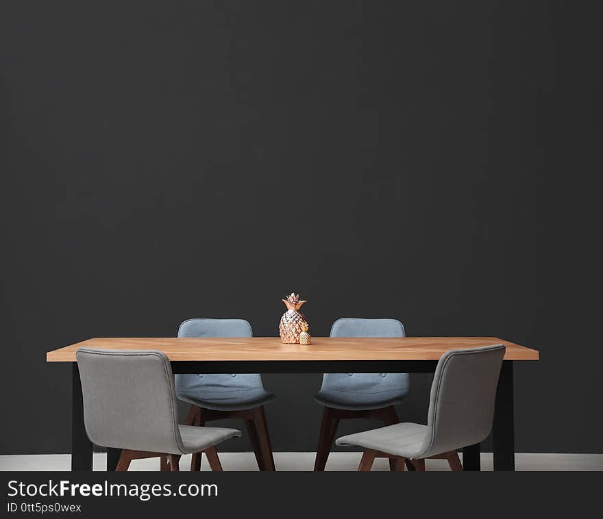 Modern Table With Decorative Pineapples Near Wall