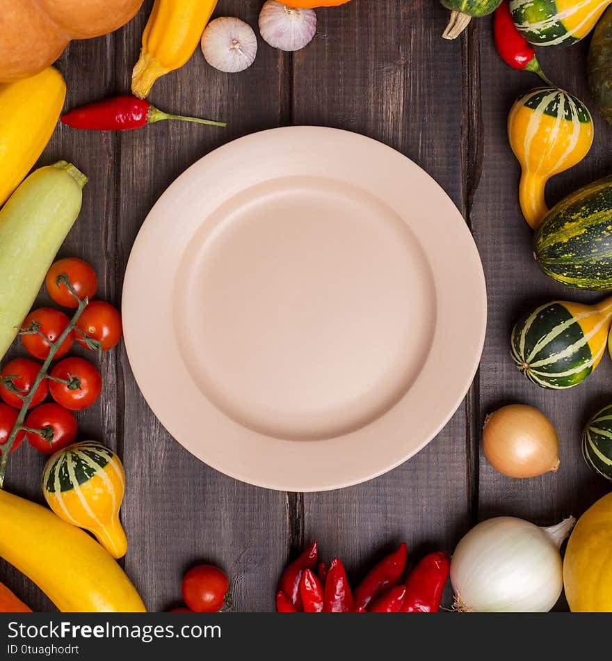 Background with empty plate and harvest vegetables around