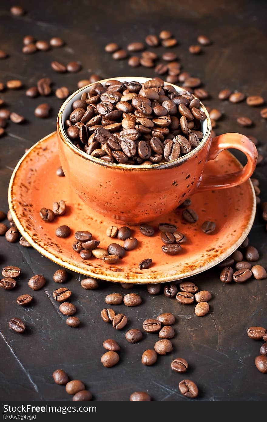 Food  background  with  black roasted coffee beans in ceramic mug, selective  focus with  shallow depth of field. Food  background  with  black roasted coffee beans in ceramic mug, selective  focus with  shallow depth of field