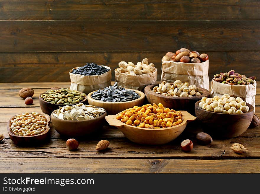 Salted seeds and nuts on wooden table background