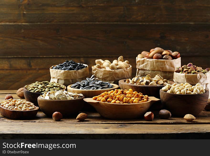 Salted seeds and nuts on wooden table background