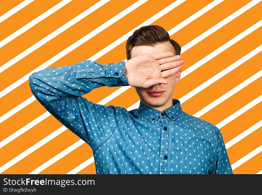 Portrait of upset man covering his face with hand.