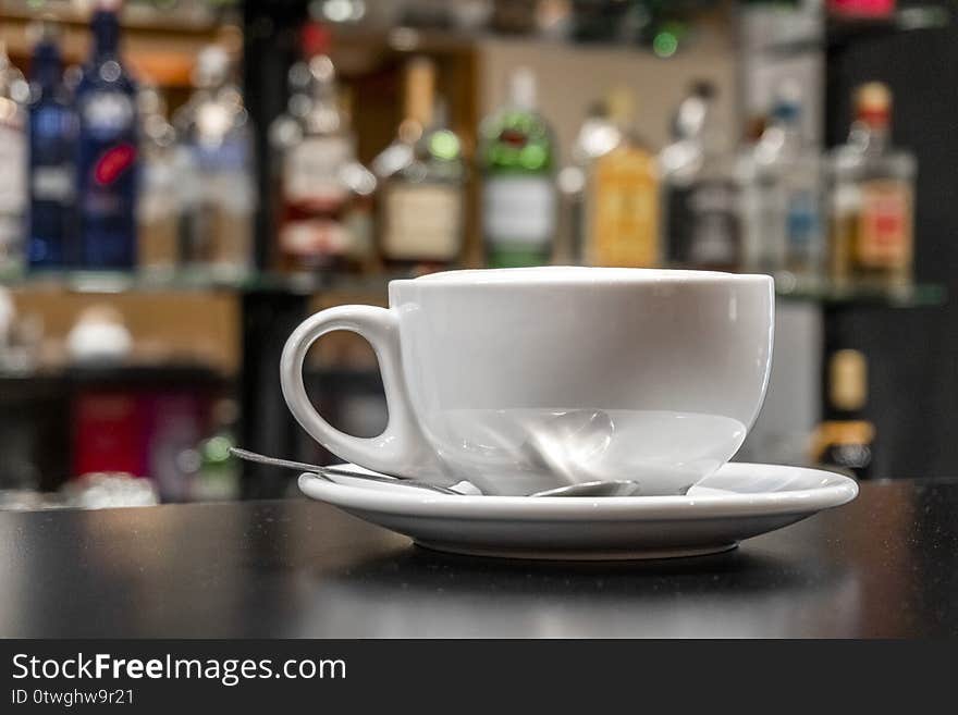 Coffee Latte in white cup with silver tea spoon in the bar. Coffee Latte in white cup with silver tea spoon in the bar