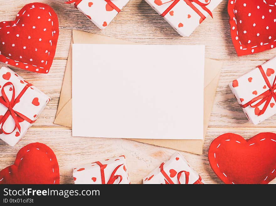 Envelope Mail with Red Heart and gift box over Orange Wooden Background. Valentine Day Card, Love or Wedding Greeting Concept.