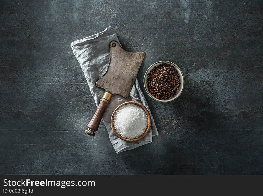 Old meat butcher on dark concrete board with spices salt and pepper