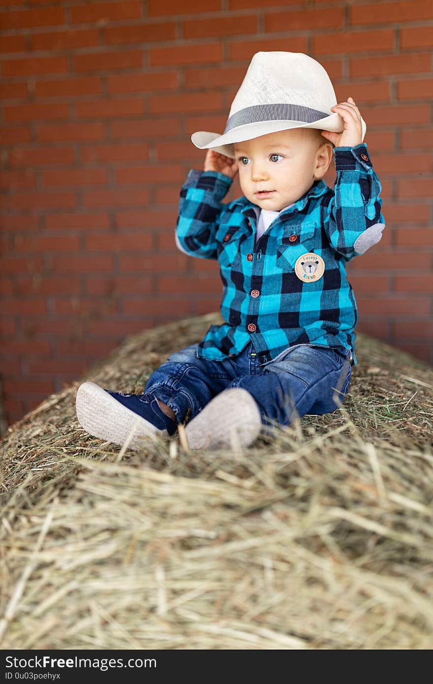 Podlak. boy in a hat sitting on hay