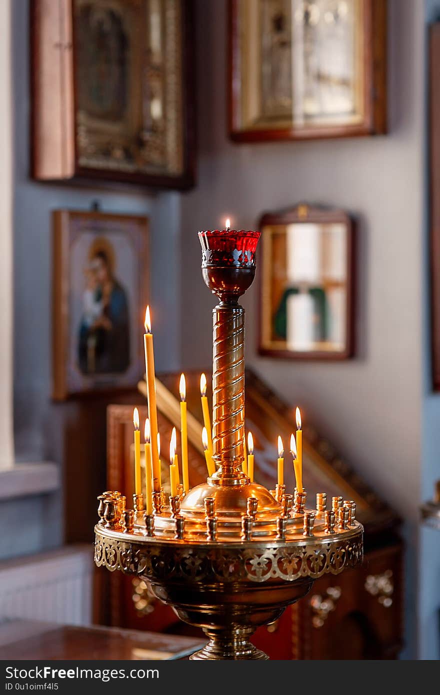 Decoration of the Orthodox Church, Church candlestick with burning candles, icons in the background in the background