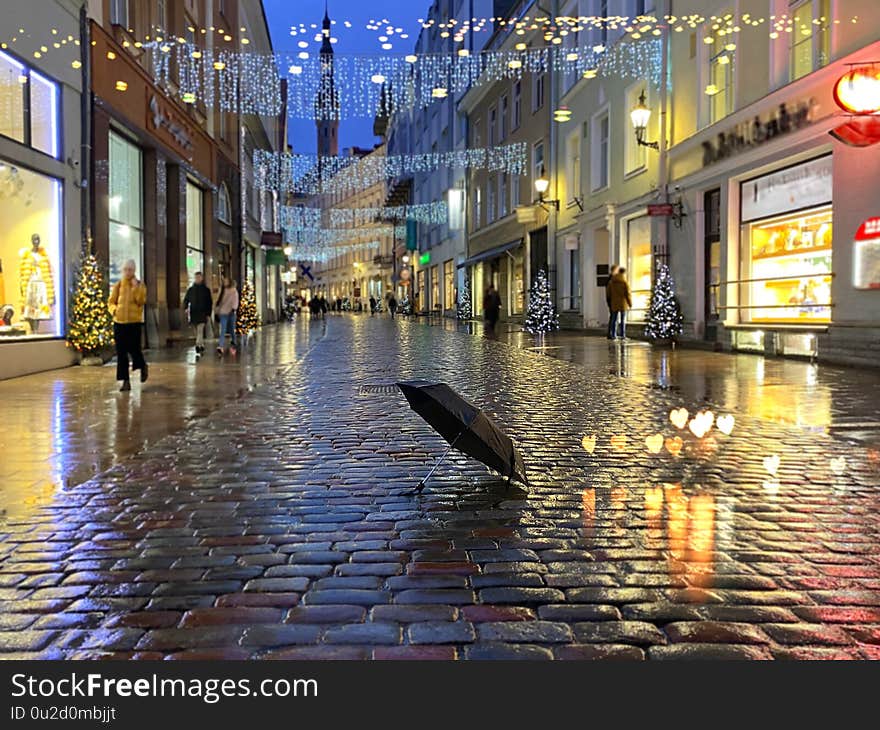 Rainy  City Christmas Tallinn Old town street night  light people walking with umbrellas rain drops reflection on window