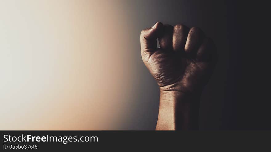 Fist of male hand with light in vintage tone background. Fist of male hand with light in vintage tone background