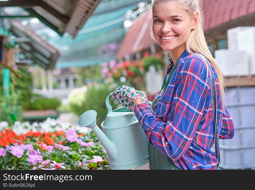 Young woman gardening in greenhouse.She selecting flowers .