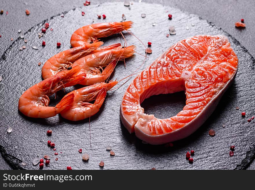 Raw trout red fish steak served with herbs and lemon and olive oil on a dark background. Cooking Salmon, sea food. Healthy eating concept