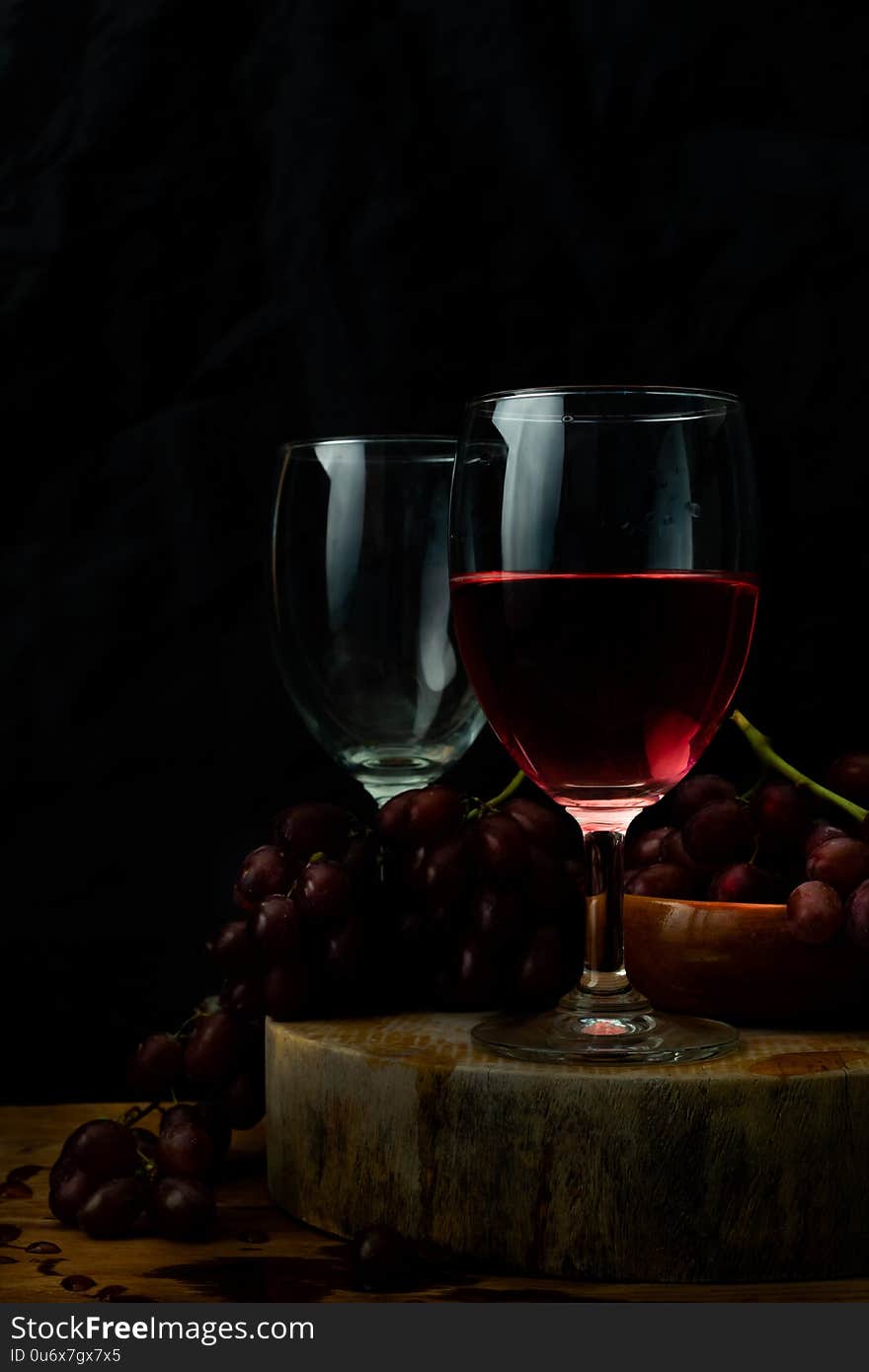 Red wine and grapes on wooden table.The concept of food and drink