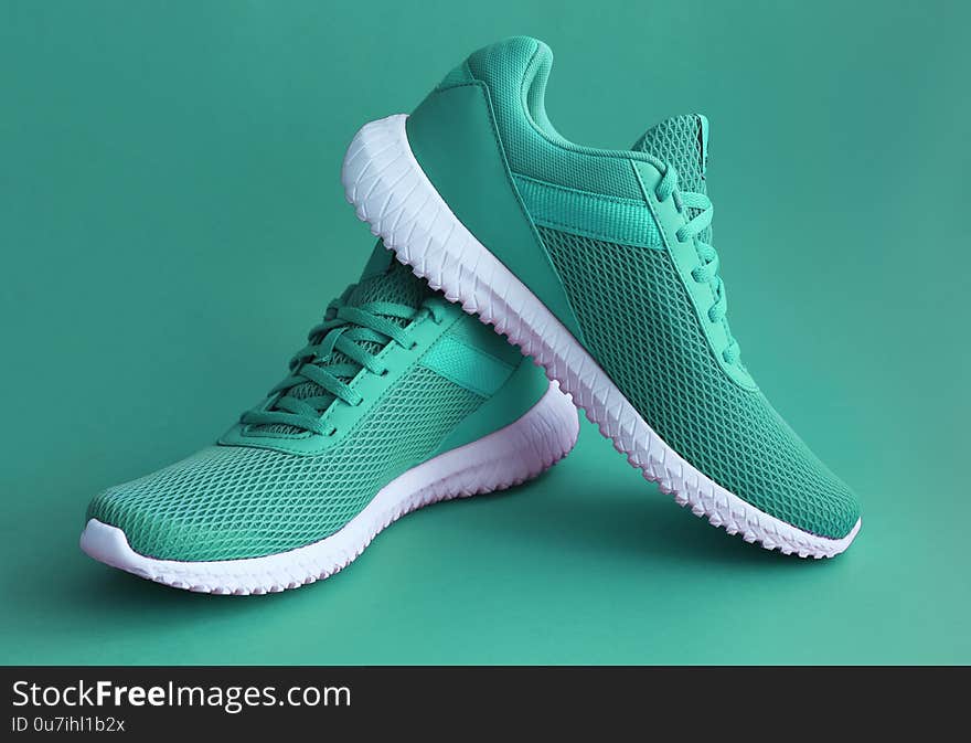 Colorful sport shoes on green color backround. Modern fashion sneakers print concept