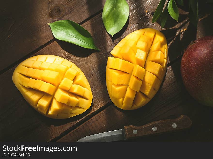 Mango halved and cubed. Tropical fruit on a wooden table. Top view