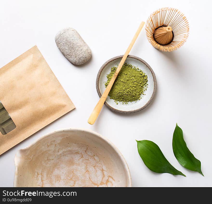 White ceramic spoon with tea of a Matcha on a light gray background. Matcha green tea in powder