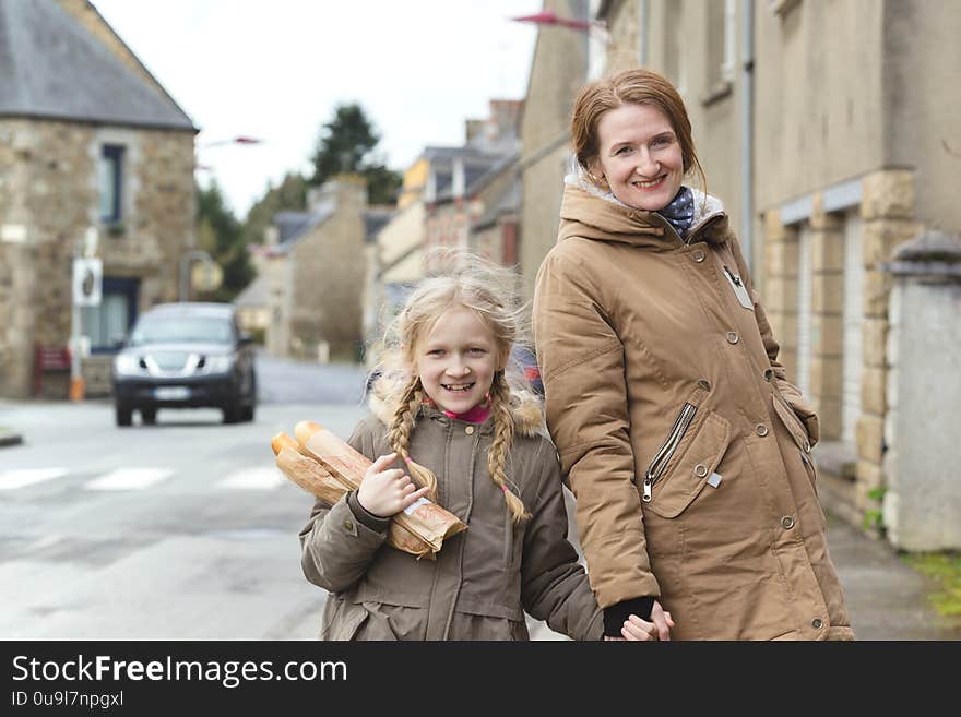 French happy mother and daughter with baguettes