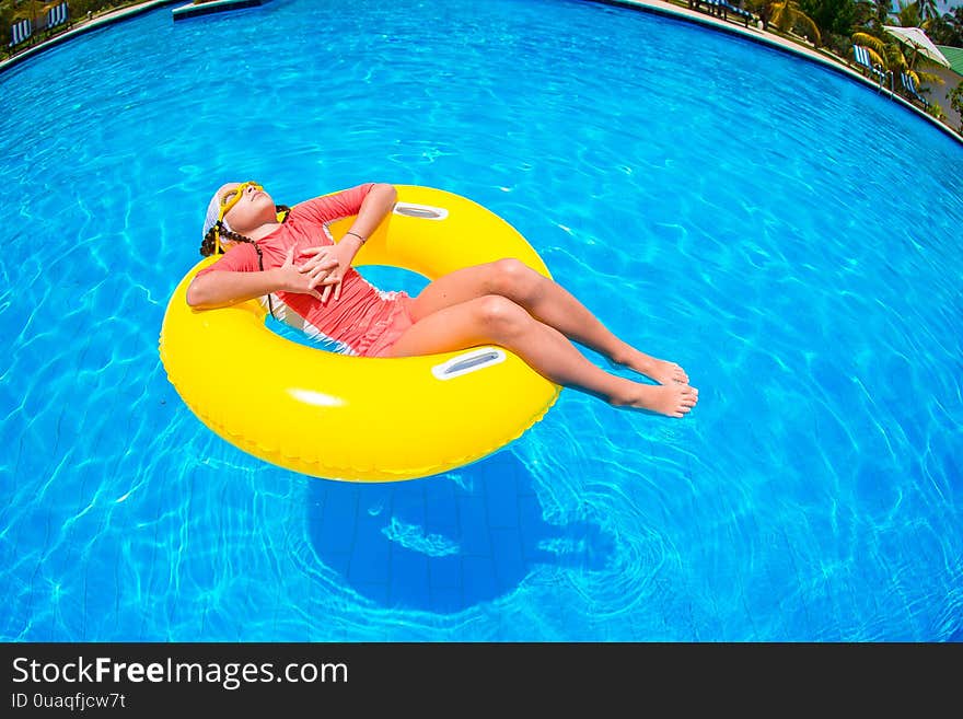 Happy kid with inflatable rubber circle having fun on the beach