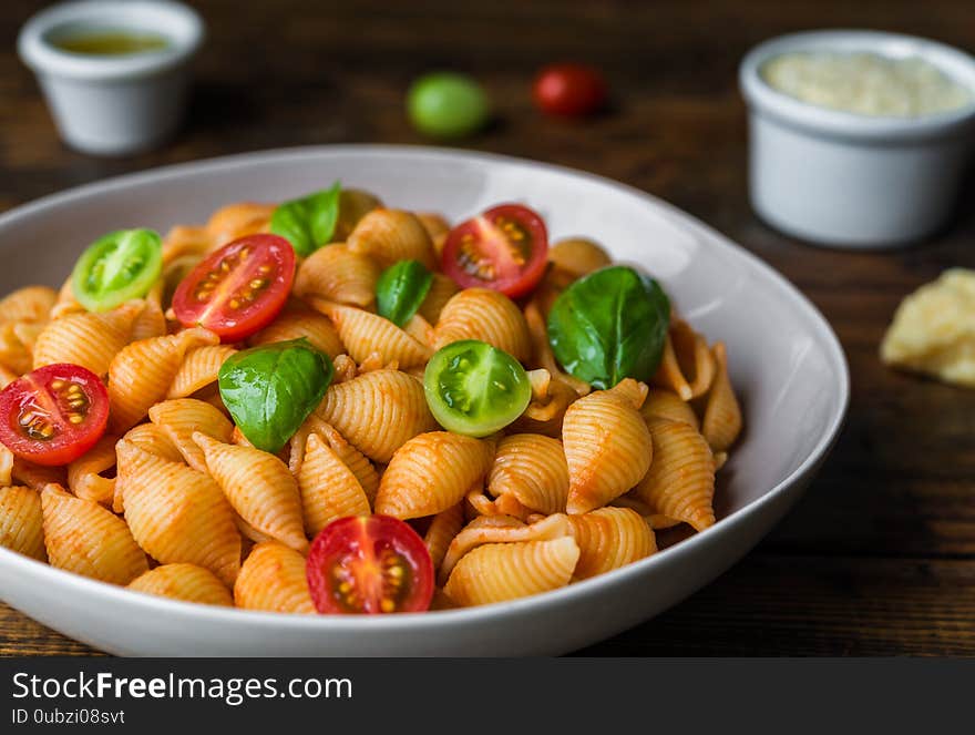 Conchiglie abissine rigate pasta with tomato sauce, cherry tomatoes, and basil.