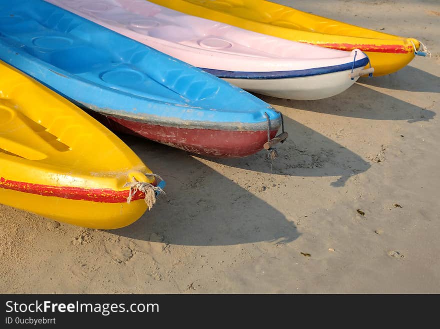 Kayaks stacked on sand beach. Colorful boats in front of sea coast. Vacation and travel sport activity. Free copy space