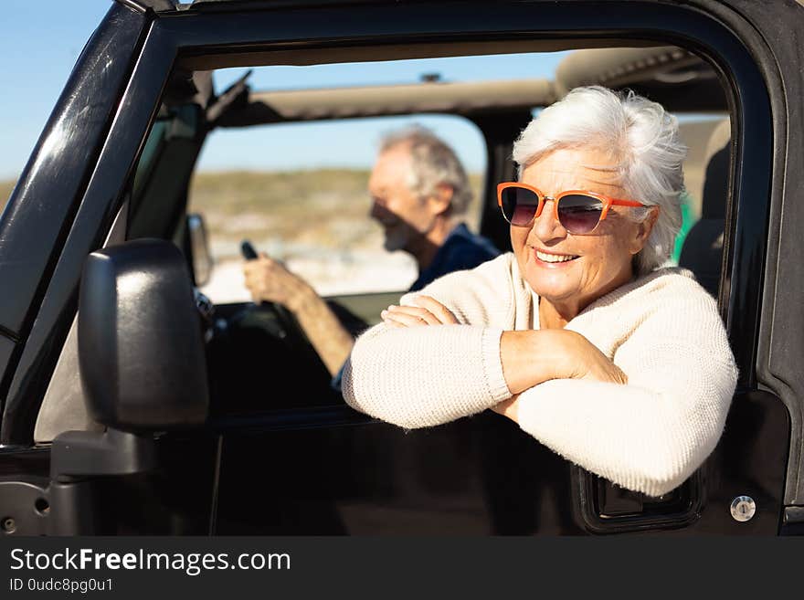 Old couple with a car at the beach