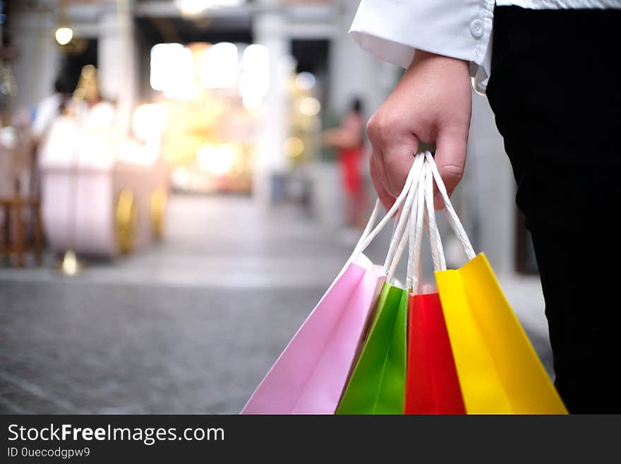 Asian girls holding sale shopping bags. consumerism lifestyle concept in the shopping mall.