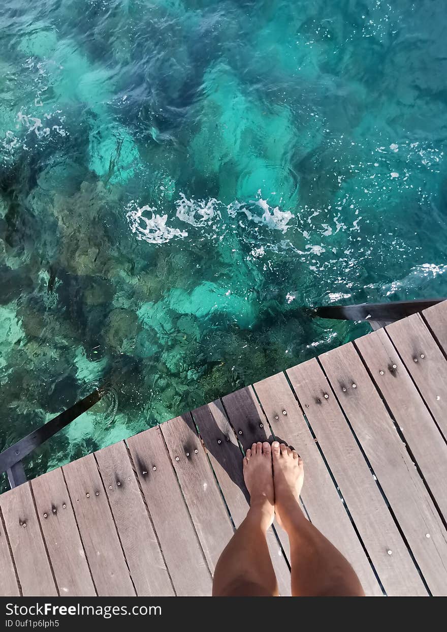 Woman standing on the jetty with beautiful clear water from the surface in Mabul Island, Semporna. Tawau, Sabah. Malaysia. The Land Below The Wind.